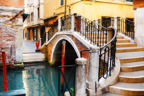 Canal en Venecia, Italia y coloridos edificios con un puente peatonal — Foto de Stock