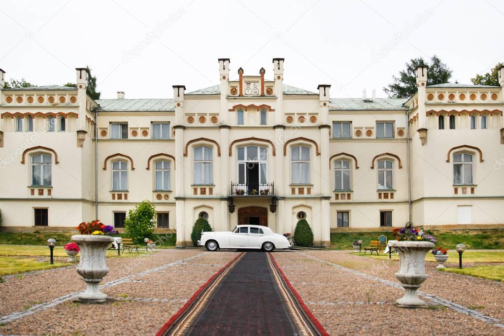 Exterior of a beautiful old house with white retro car