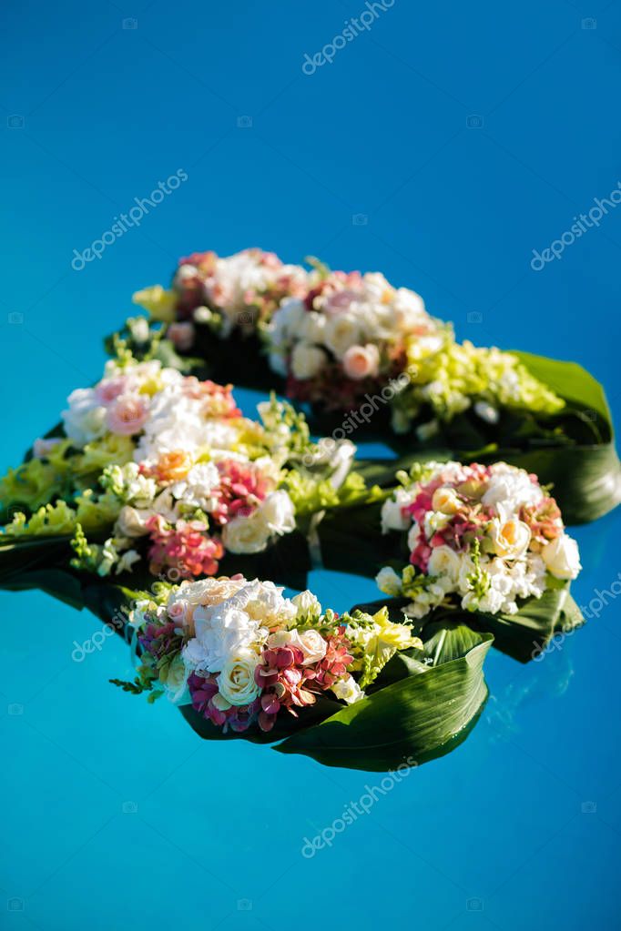 Colorful flowers float in the pool. Wedding decoration