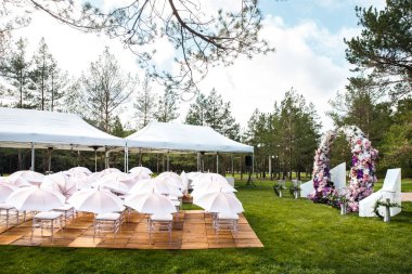 Açık hava düğün töreni ormandaki şemsiyelerle