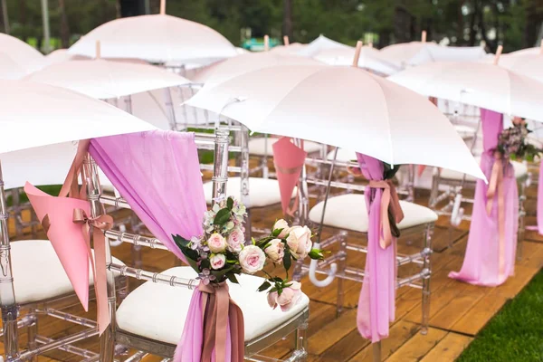 Chairs, flowers and umbrellas at an outdoor ceremony — Stock Photo, Image