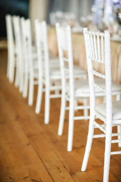 A row of white chairs next to the wedding tables — Stock Photo, Image
