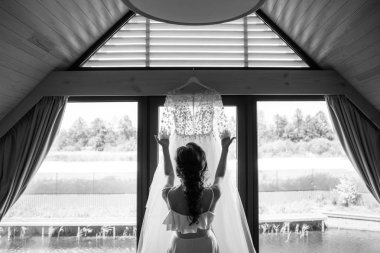 Gelin gelinlik pencere yakınındaki bir askı tutan