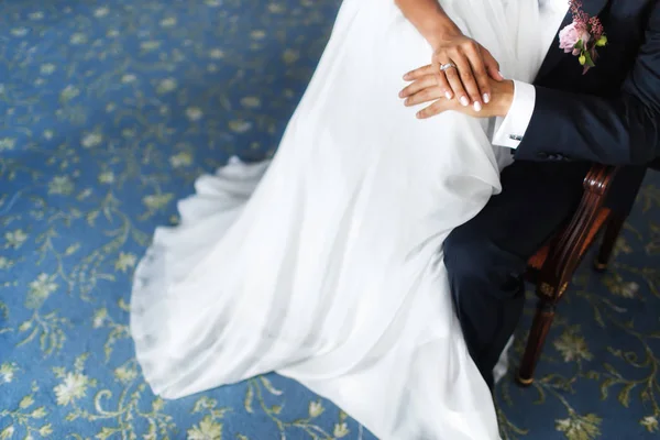 Hands of the bride and groom on the dress — Stock Photo, Image