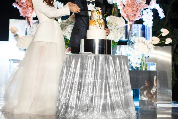 Наречений і наречений на весіллі прийом різання весільного торта з квітами — стокове фото