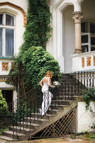 Giovane sposa sui gradini di pietra di una bella villa — Foto Stock