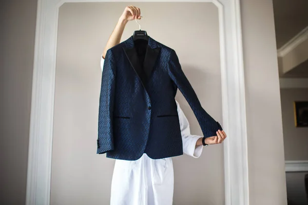 The groom in a robe holding a suit — Stock Photo, Image
