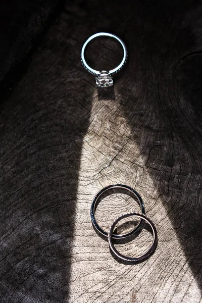 Tres anillos de boda sobre un fondo de madera — Foto de Stock