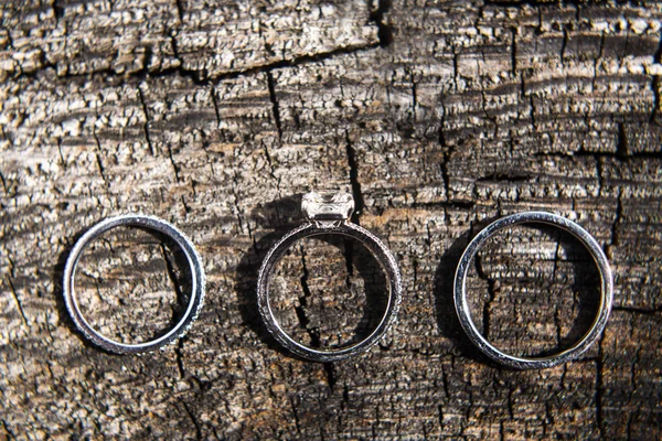 Tres anillos de boda sobre un fondo de madera —  Fotos de Stock