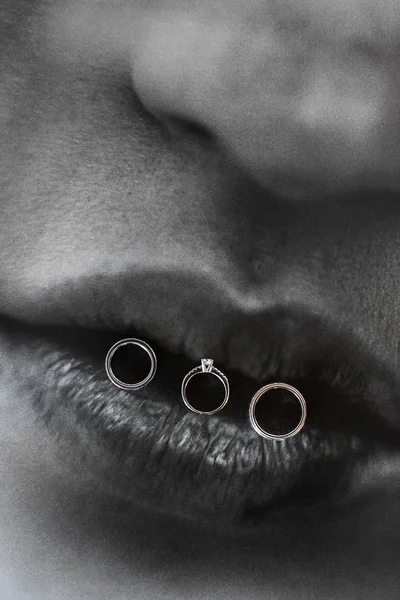 Drei Eheringe an den Lippen. Hochzeitstag — Stockfoto