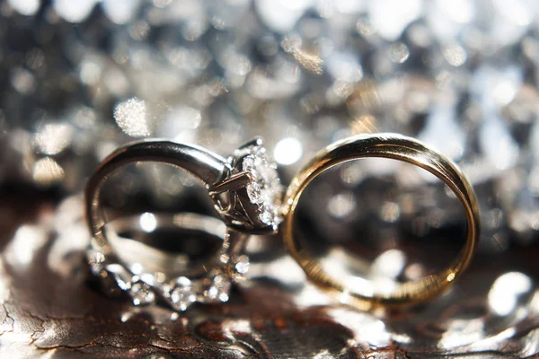 Tres anillos de boda en la superficie reflectante con reflejos — Foto de Stock