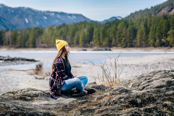 Жінка сидить на березі гірського озера — стокове фото