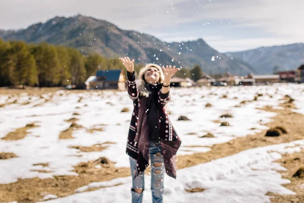 Chica en un jersey de punto lanza nieve — Foto de Stock