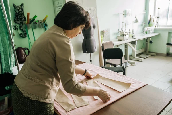 Kadın profesyonel terzi bir elbise modeli yapar