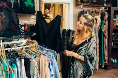 Kız mağazadan kıyafet seçiyor.