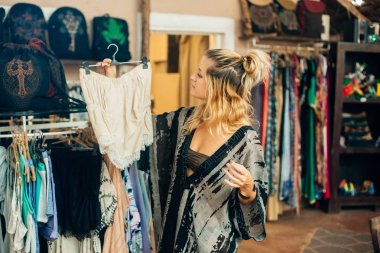 Kız mağazadan kıyafet seçiyor.