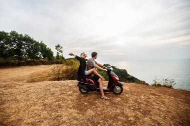 uçurumdan denize sıfır gün batımı çerçevede bir motorla Lovers