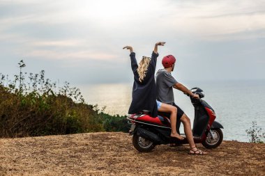 uçurumdan denize sıfır gün batımı çerçevede bir motorla Lovers