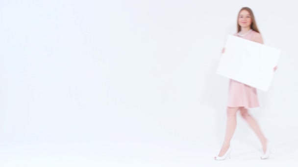 Улыбающаяся привлекательная девушка в розовом платье ходит и смотрит в камеру — стоковое видео