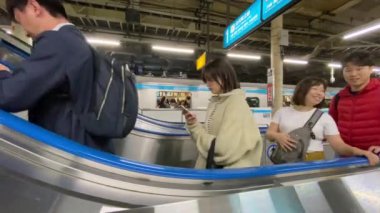Tokyo, Japonya - Kasım 2019: Yürüyen merdivendeki insanlar