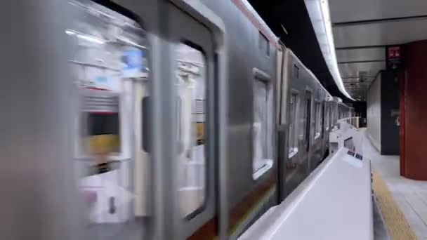 Tokyo, Giappone - Circa novembre 2019: un treno della metropolitana passa davanti alla stazione — Video Stock