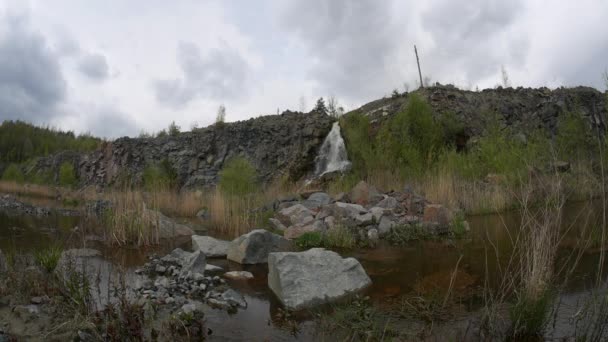 Mijnbouw graniet, ondergrondse rivieren, watervallen en graniet groeve met een waterval in het voorjaar, watervallen op graniet, een blauwe hemel in een graniet steengroeve, een berg rivier. — Stockvideo