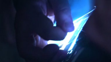 Bir adam bir elektro gitar çalar. Elimi parlak ışık. El ve dizeleri - kadar karanlık bir odada kapatın. Ağır çekim.