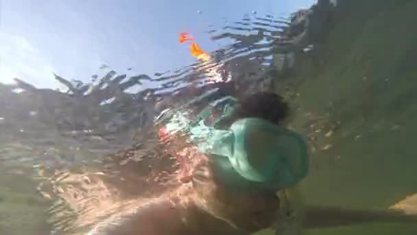 Mladý muž, plovoucí pod vodou v masce s trubkou je plovoucí na slunci. — Stock video