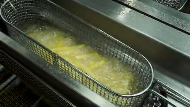 Batatas de palha em fatias frescas são imersas em óleo fervente, esperando para serem fritas — Vídeo de Stock
