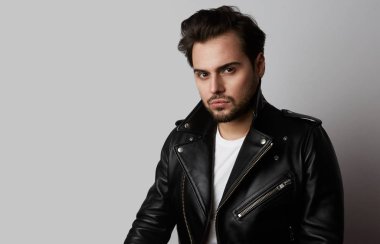 Dramatik moda model beyaz arka plan üzerinde dururken dinlenme deri ceketli. Yatay.