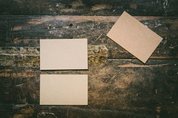 Conjunto recheado de três cartões de visita artesanais em branco na mesa de madeira autêntica marrom natural. Business vazio fundo mock-up para a mensagem writing.Top conceito vista . — Fotografia de Stock