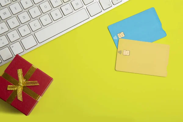 Makett két üres színes hitelkártyák, ajándék doboz üres sárga asztalon. Üzleti modell háttérben üzenet írása. Felülnézet. Vízszintes. — Stock Fotó