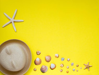 Yaz şapka ve kabukları ve denizyıldızı, sarı bir arka plan üzerinde bulunan bir seçim.