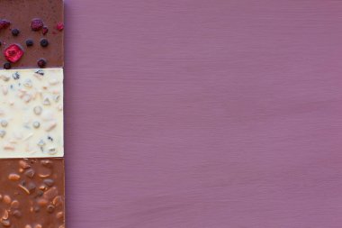 Mor bir arka plan üzerinde çikolata. Çikolata. Çikolata. Fındıklı çikolata.