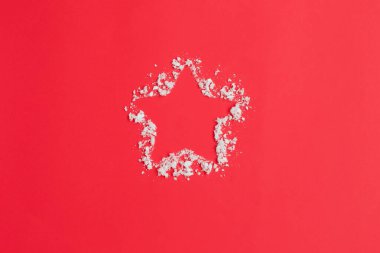 Kırmızı zemin üzerinde yıldız ve kar. Noel kompozisyonu.