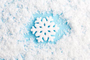 Mavi arka planda kar tanesi ve kar. Noel kompozisyonu.