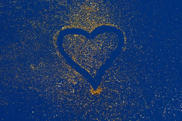 Un corazón hecho de brillo dorado sobre fondo de tendencia azul . — Foto de Stock