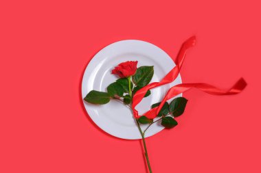 Kırmızı gül ve kırmızı zemin üzerinde beyaz plaka olan Sevgililer Günü konsepti.