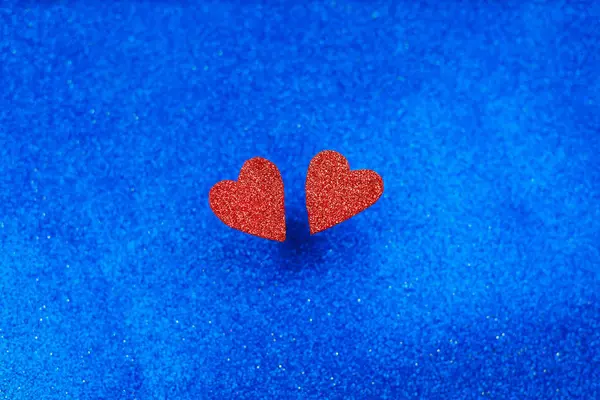 Twee rode hartjes op blauwe houten achtergrond, close-up, — Stockfoto