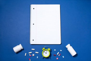 Tıp, alarm saati ve tıp konseptini almak için boş defter