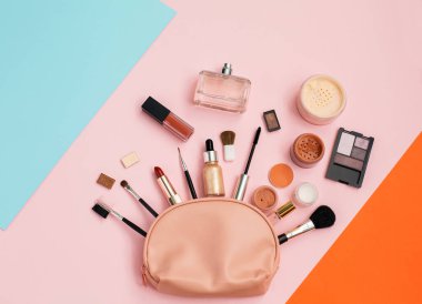 Renkli pembe makyaj çantasından dekoratif kozmetik seti. Metnin için alanı kopyala. Üst manzara, düz uzanma.