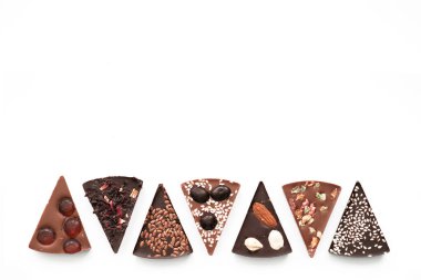 Fındıklı el yapımı çikolata, kurutulmuş meyve, beyaz arka planda tohumlar. Çikolata. Siyah ve sütlü çikolata. Çikolata arkaplanı. Yemek tarifi. Boşluğu kopyala.