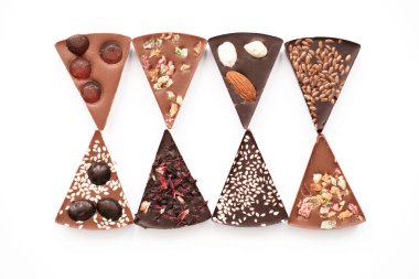 Fındıklı el yapımı çikolata, kurutulmuş meyve, beyaz arka planda tohumlar. Çikolata. Siyah ve sütlü çikolata. Çikolata arkaplanı. Yemek tarifi. Boşluğu kopyala.