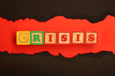 Ahşap harflerle yazılan Kriz kelimesi kırmızı ve siyah bir zeminde yatar. Ekonomik ve finansal kriz konsepti. Dünya ekonomik krizi. Üst Manzara. Düz yatıyordu