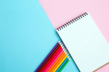 Renkli arka planda renkli kalemler ve defter. Okul ve ofis aksesuarları. Okul konsepti. düz yatay üst görünüm kopyalama alanı