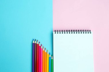 Renkli arka planda renkli kalemler ve defter. Okul ve ofis aksesuarları. Okul konsepti. düz yatay üst görünüm kopyalama alanı