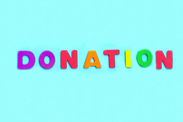 Word DONATION made of colorful letters on blue background. — Stock Photo, Image