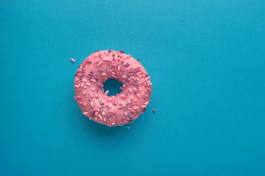 Mavi arka planda pembe çörek. Kopyala-yapıştır için yatay çerçeve.