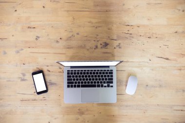 Ahşap masa üzerinde akıllı telefon ve laptop ve mosue ile Üstten Görünüm