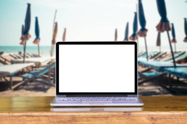 plaj ve deniz ve umbrel ile ahşap masa laptop boş ekran